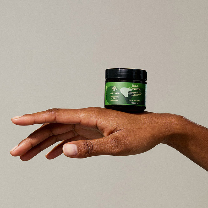 As I Am Rosemary Edge Control green label jar balanced on a hand showing hair care edge control product