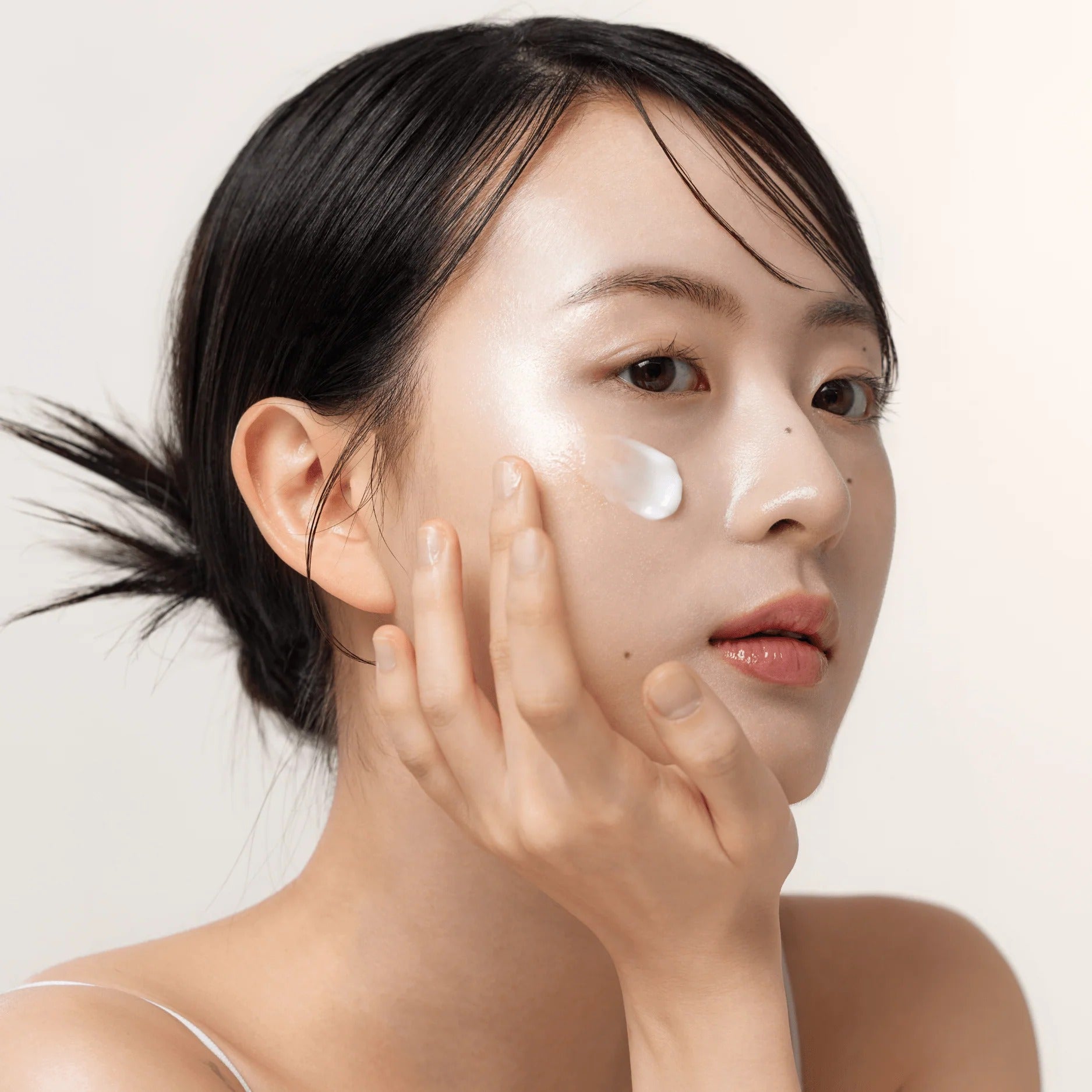 BEAUTY OF JOSEON Dynasty Cream moisturizer on model applying cream to cheek for dewy hydrated skin