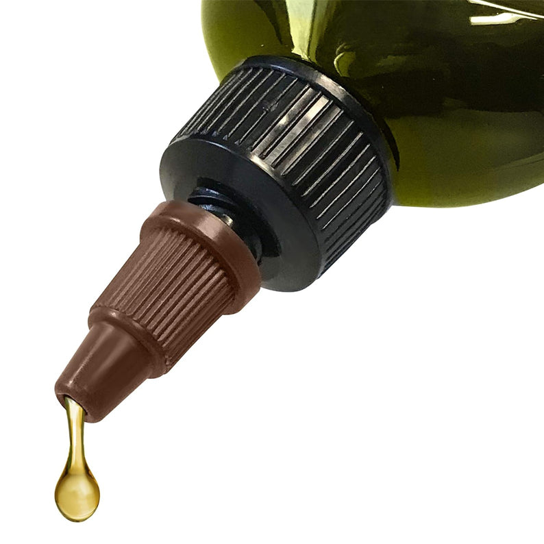 Close up of DIFEEL Jamaican black castor hair oil bottle nozzle dripping nourishing oil for scalp care