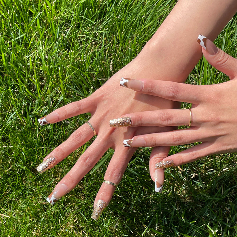 IVY BEAUTY by KISS Gold Finger trendy press on nails. Long glitter and white French press on nails on hands on grass