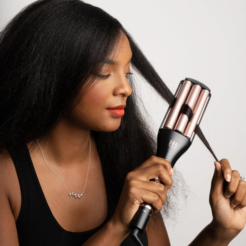 ANNIE 4-in-1 hair waver in black and rose gold used by woman to create textured waves on long hair