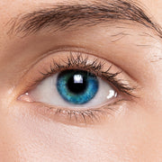 Close up of eye wearing LIZ ocean blue color contact lenses showing vibrant blue iris natural lashes and skin texture