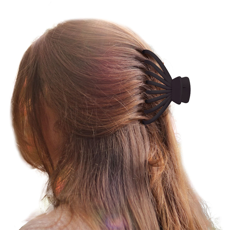 Side view of woman with long brown hair half up secured by jumbo matte butterfly claw clip in black