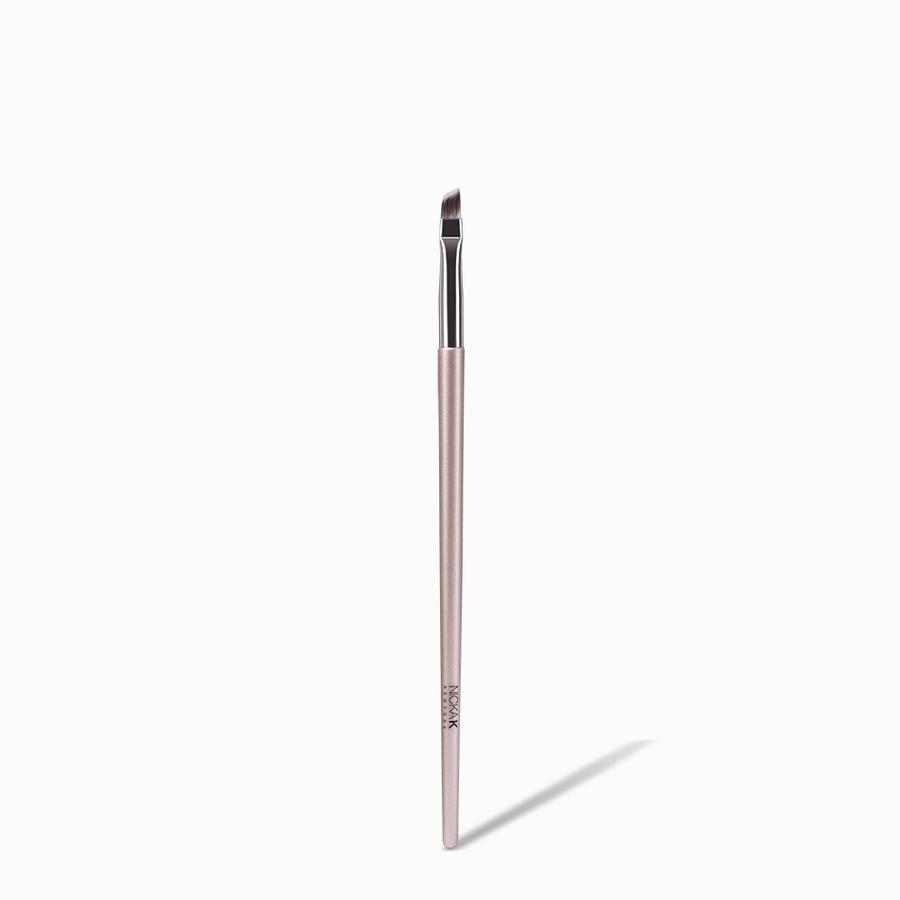 NICKA K angled eyeliner brush with rose gold handle and short dense angled bristles for precise liner