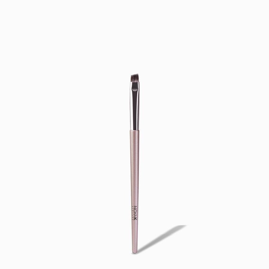 NICKA K angled eyebrow brush for makeup with slim rose gold handle and angled bristles for precision