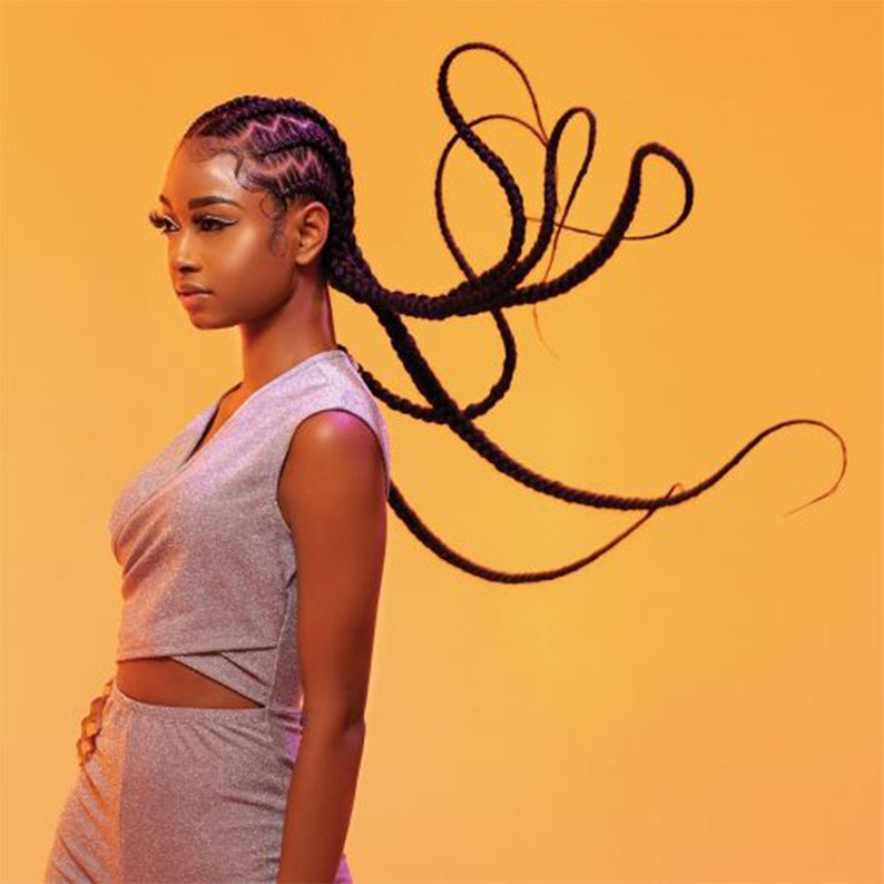 SENSATIONNEL pre-stretched braiding hair 58 inch styled in long, flowing braids on a woman with a yellow background